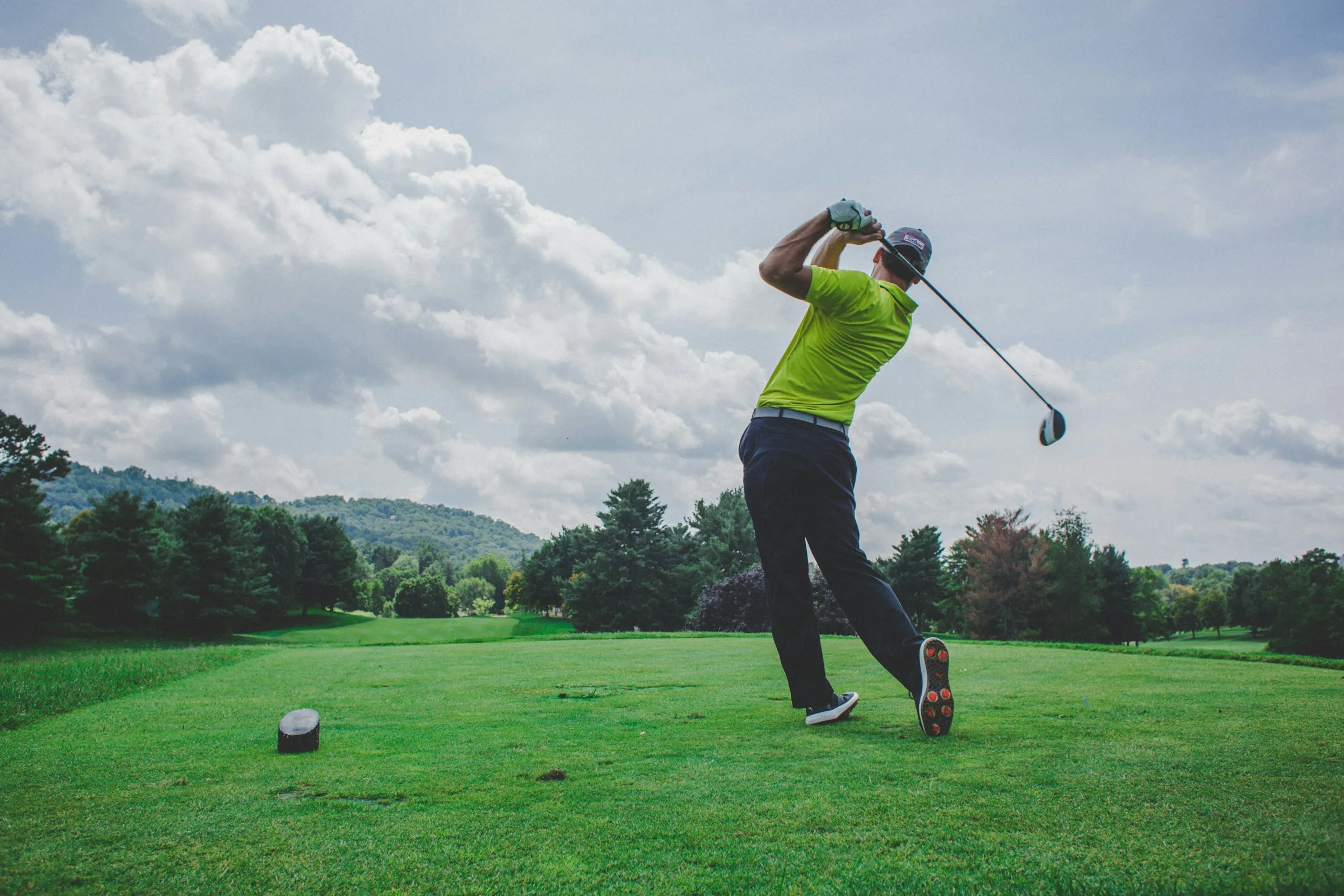 Golfer mid-swing on a golf course